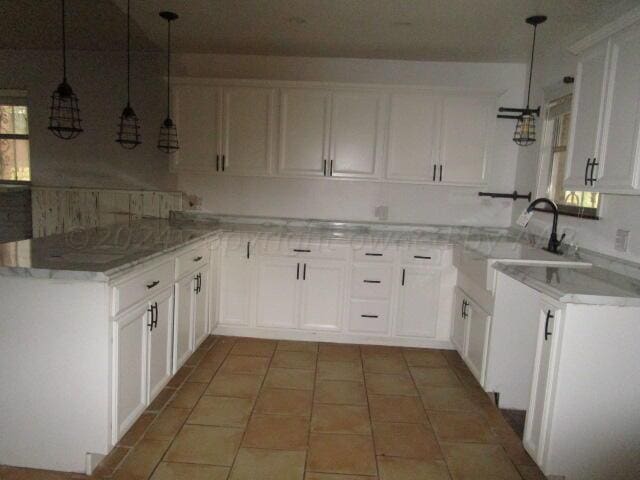 kitchen featuring kitchen peninsula, sink, and white cabinets