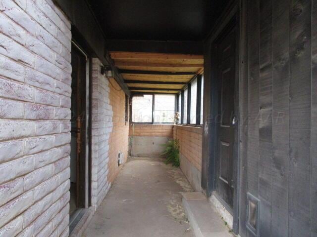 hallway featuring brick wall