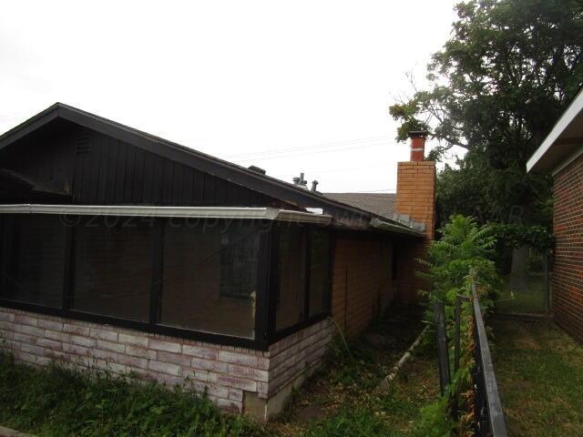 view of property exterior featuring a sunroom