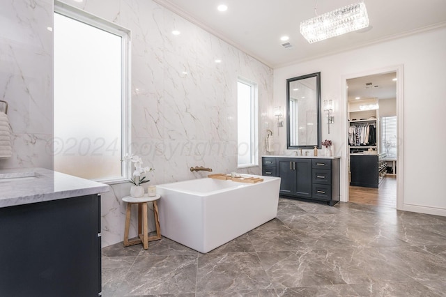 bathroom featuring vanity, crown molding, a tub to relax in, tile walls, and a healthy amount of sunlight