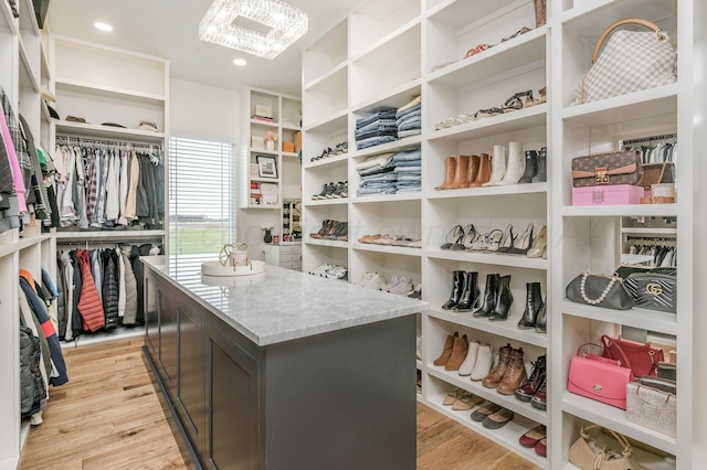 walk in closet with light hardwood / wood-style floors