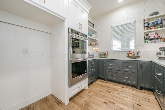 kitchen featuring decorative backsplash, gray cabinetry, double oven, light hardwood / wood-style flooring, and white cabinetry