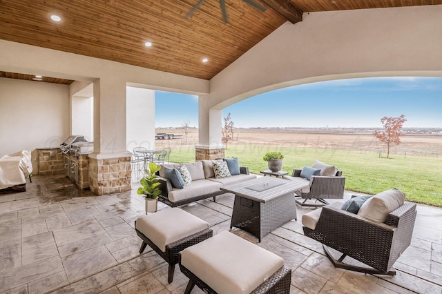 view of patio / terrace featuring an outdoor hangout area, grilling area, a rural view, and an outdoor kitchen