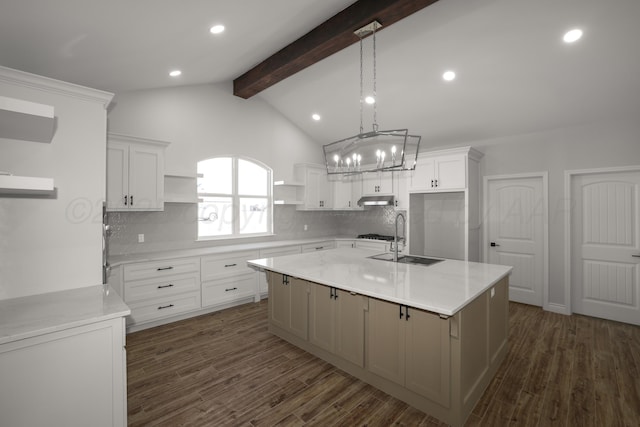 kitchen with backsplash, a center island with sink, and white cabinets