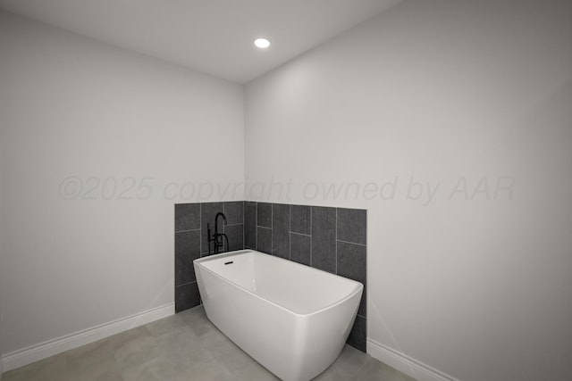 bathroom with tile patterned flooring and a bath