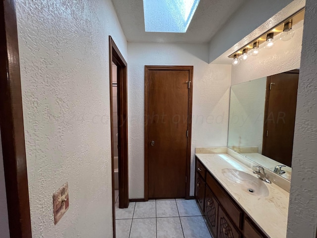 bathroom with vanity, a skylight, and tile patterned floors