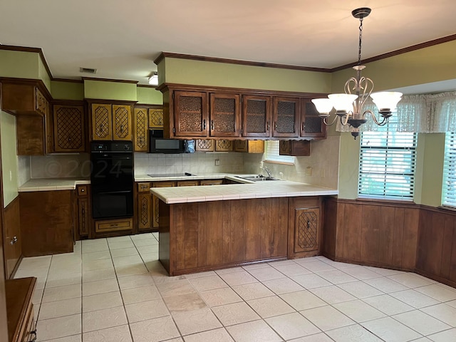 kitchen featuring black appliances, wood walls, kitchen peninsula, and dark brown cabinets