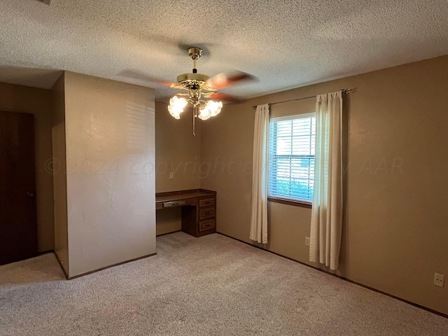 unfurnished room featuring a textured ceiling, light carpet, and ceiling fan