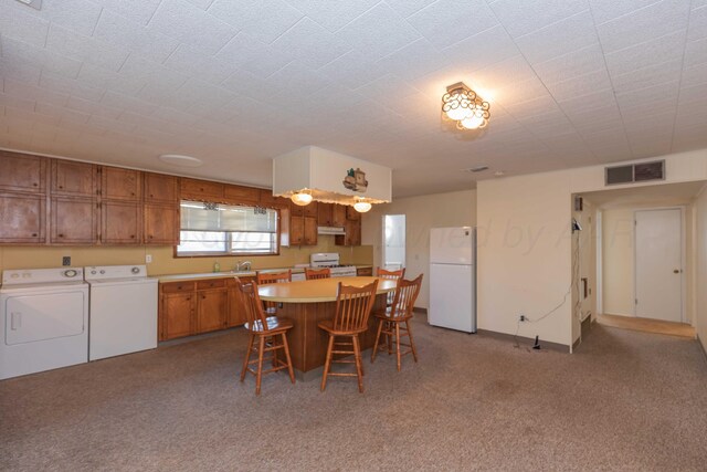 dining room with light carpet, washer and clothes dryer, and sink