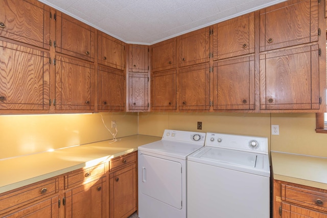 clothes washing area with cabinets, independent washer and dryer, and crown molding