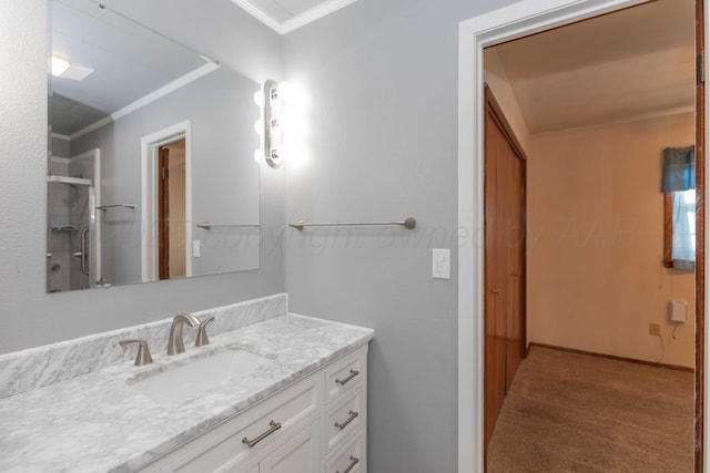 bathroom featuring vanity, a shower with shower door, and crown molding