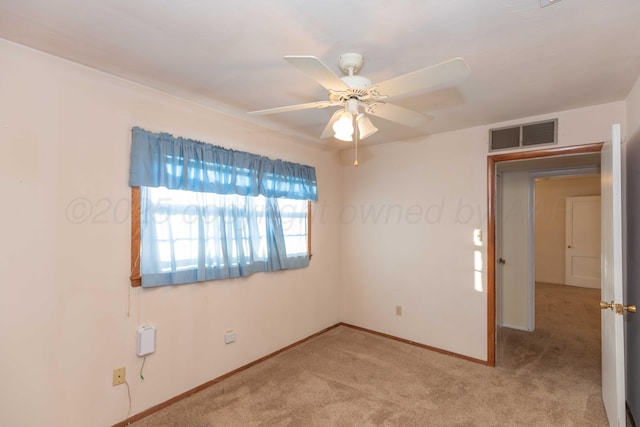 empty room featuring ceiling fan and light colored carpet