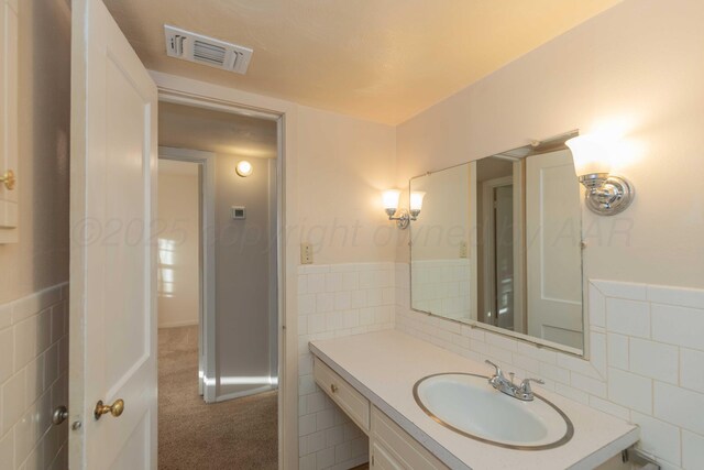 bathroom with vanity and tile walls