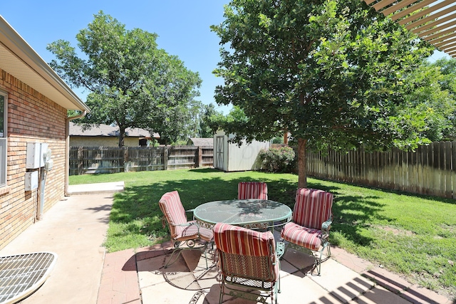 1206 Olive St, Stratford, TX 79084 - fenced backyard featuring a patio area, outdoor dining area, and a storage unit