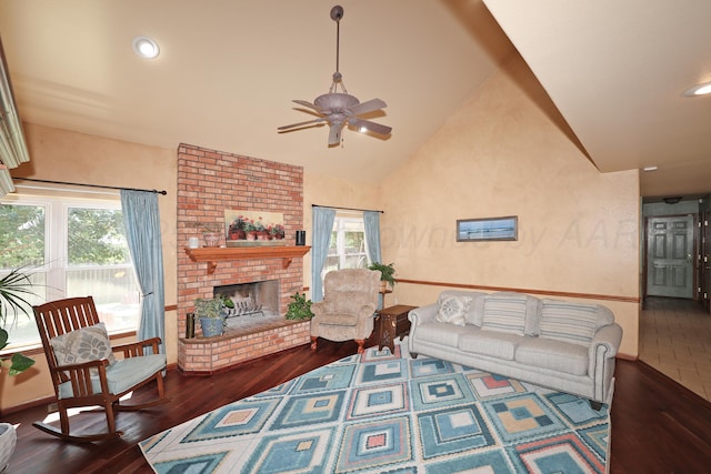 1206 Olive St, Stratford, TX 79084 - living room featuring ceiling fan, healthy amount of natural light, lofted ceiling, wood finished floors, and a brick fireplace