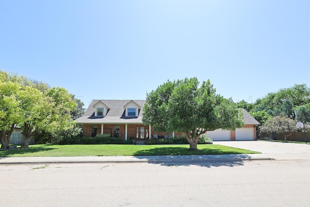 1206 Olive St, Stratford, TX 79084 - cape cod home with concrete driveway, an attached garage, and brick siding