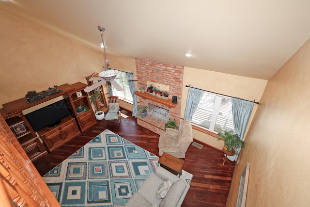 1206 Olive St, Stratford, TX 79084 - living area featuring a brick fireplace, wood finished floors, and plenty of natural light
