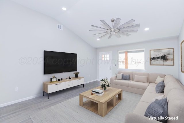 living room featuring ceiling fan, vaulted ceiling, and light hardwood / wood-style floors