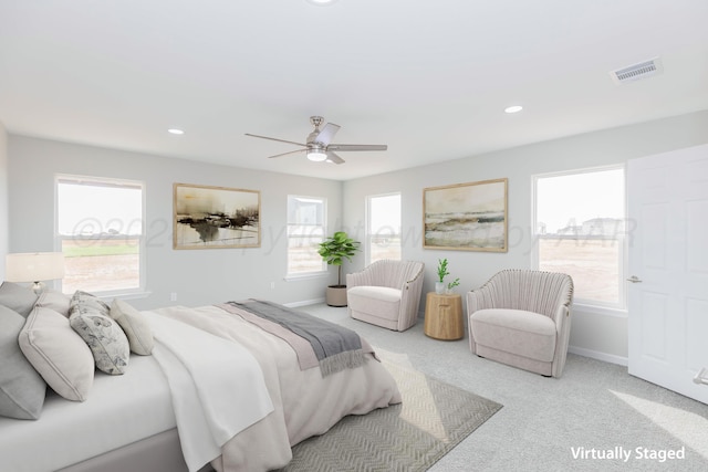 carpeted bedroom featuring ceiling fan and multiple windows