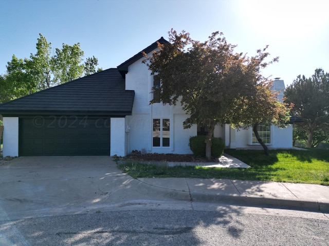 view of front of property featuring a garage and a front lawn