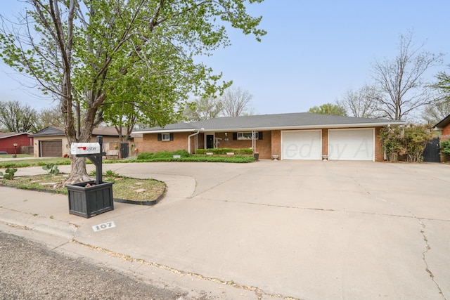 107 Elm St, Hereford, TX 79045 - ranch-style home with a garage, brick siding, and concrete driveway