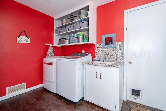 107 Elm St, Hereford, TX 79045 - washroom featuring a sink, dark wood-style flooring, washing machine and dryer, visible vents, and cabinet space