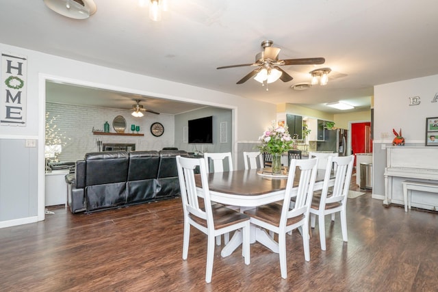 107 Elm St, Hereford, TX 79045 - dining room with a ceiling fan, a wainscoted wall, dark wood-type flooring, and a fireplace