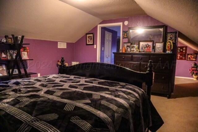 bedroom featuring a textured ceiling, lofted ceiling, and carpet floors