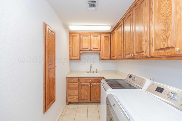 2408 Drake Elm Pl, Amarillo, TX 79124 - laundry area featuring separate washer and dryer, cabinet space, and light tile patterned floors