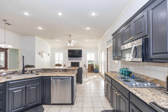 2408 Drake Elm Pl, Amarillo, TX 79124 - kitchen with appliances with stainless steel finishes, ceiling fan, a fireplace, crown molding, and light stone countertops