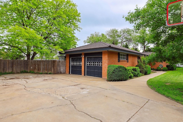 view of side of home featuring a tiled roof, brick siding, and fence