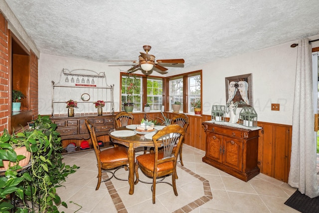 dining area featuring a ceiling fan, a textured ceiling, and light tile patterned floors