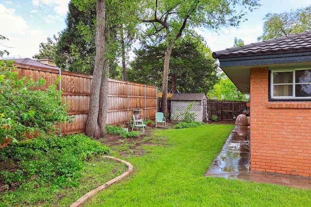 view of yard with a fenced backyard, an outdoor structure, and a shed