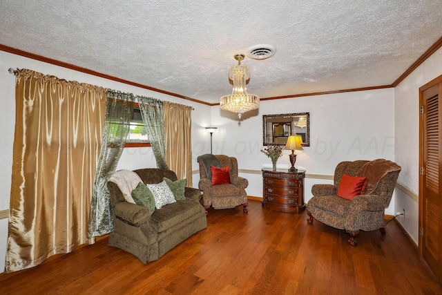 living area with visible vents, baseboards, a textured ceiling, and wood finished floors