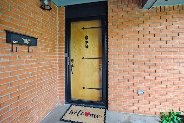 doorway to property featuring brick siding