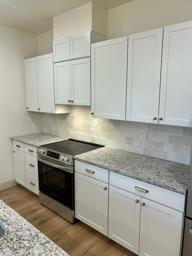 2 S Hunsley Hills Blvd, Canyon, TX 79015 - kitchen featuring stainless steel range with electric stovetop, wood finished floors, white cabinets, and decorative backsplash