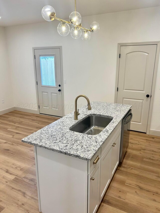 2 S Hunsley Hills Blvd, Canyon, TX 79015 - kitchen featuring a sink, an island with sink, light wood-style floors, and pendant lighting