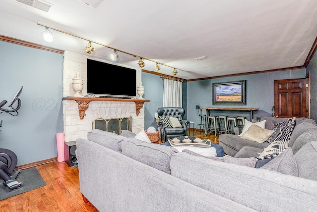 3208 S Ong St, Amarillo, TX 79109 - living area featuring ornamental molding, wood finished floors, a stone fireplace, and rail lighting
