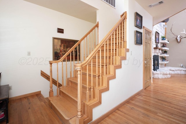 2402 Ghost Dance Trl, Amarillo, TX 79124 - stairs with wood finished floors, a wood stove, and baseboards