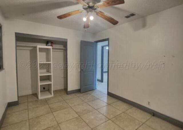 unfurnished bedroom with ceiling fan and light tile patterned floors