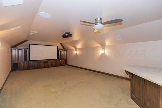 carpeted cinema with ceiling fan and vaulted ceiling