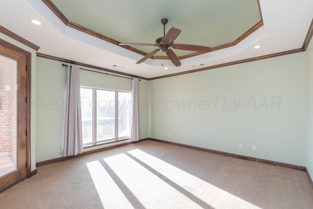 empty room with ceiling fan, ornamental molding, and a tray ceiling