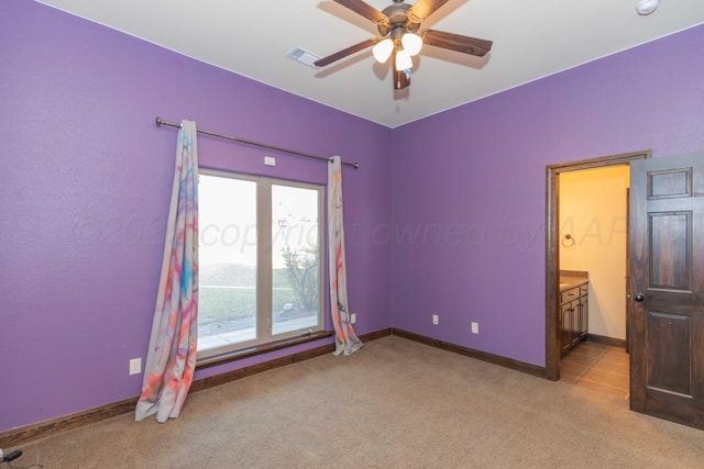 unfurnished bedroom with light carpet, connected bathroom, and ceiling fan