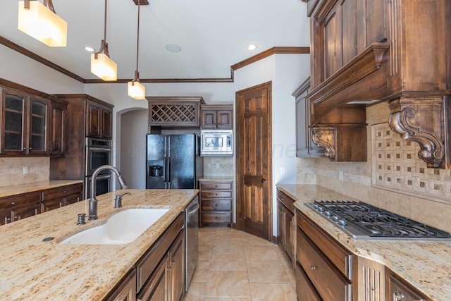 kitchen featuring sink, stainless steel appliances, tasteful backsplash, crown molding, and decorative light fixtures