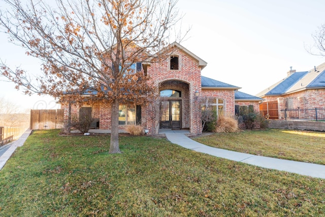 view of front of house with a front yard and french doors