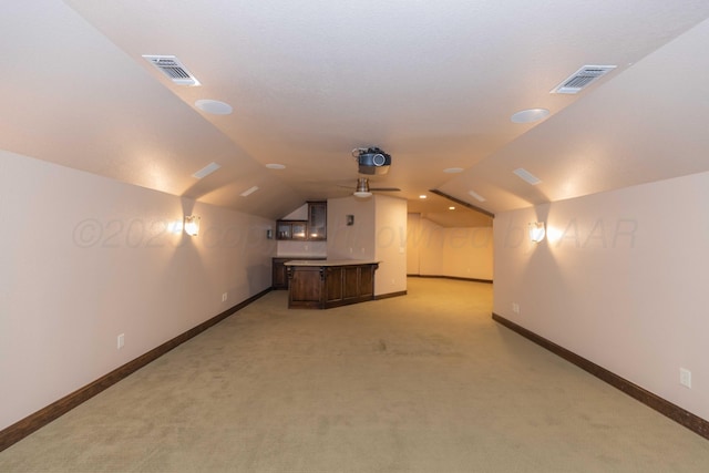 additional living space featuring ceiling fan, light carpet, and lofted ceiling