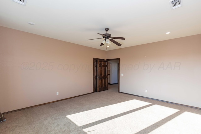 empty room with ceiling fan and light carpet