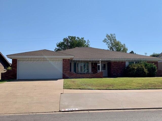 ranch-style house featuring a garage and a front yard