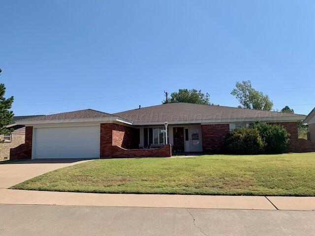 single story home featuring a garage and a front lawn