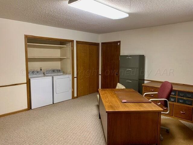 home office with light colored carpet, a textured ceiling, and independent washer and dryer